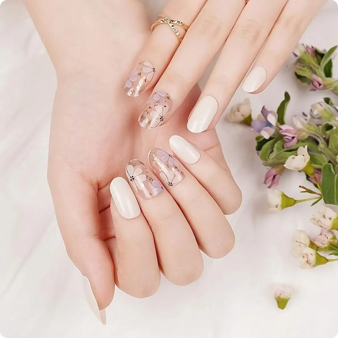Petals nail design: long nude-beige nails with white tips, delicate floral decals, and dots