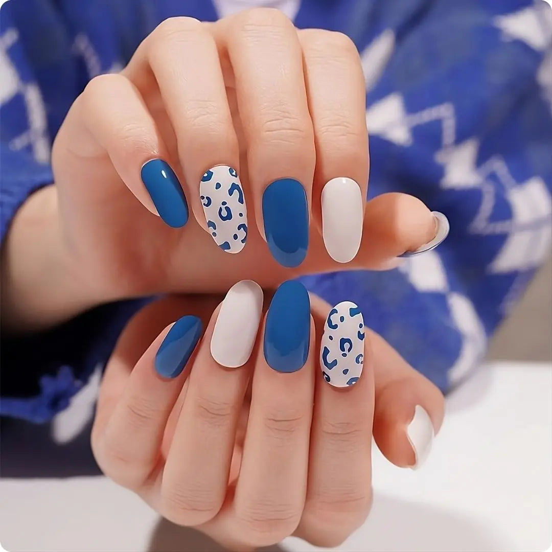 Hands with blue leopard nail design: deep-blue, white, and spotted leopard-print nails