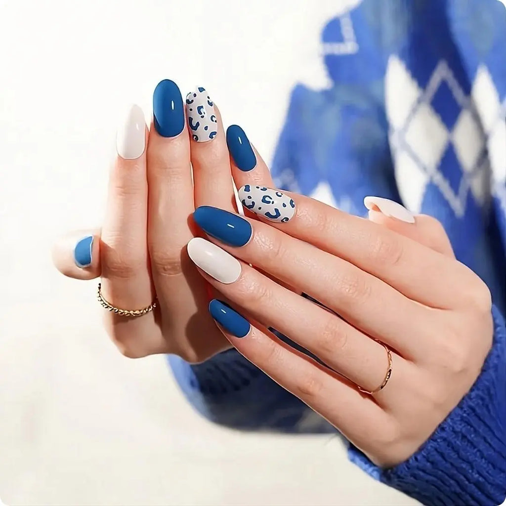 Blue leopard nail style on two hands: deep-blue, white, and leopard-print accent nails
