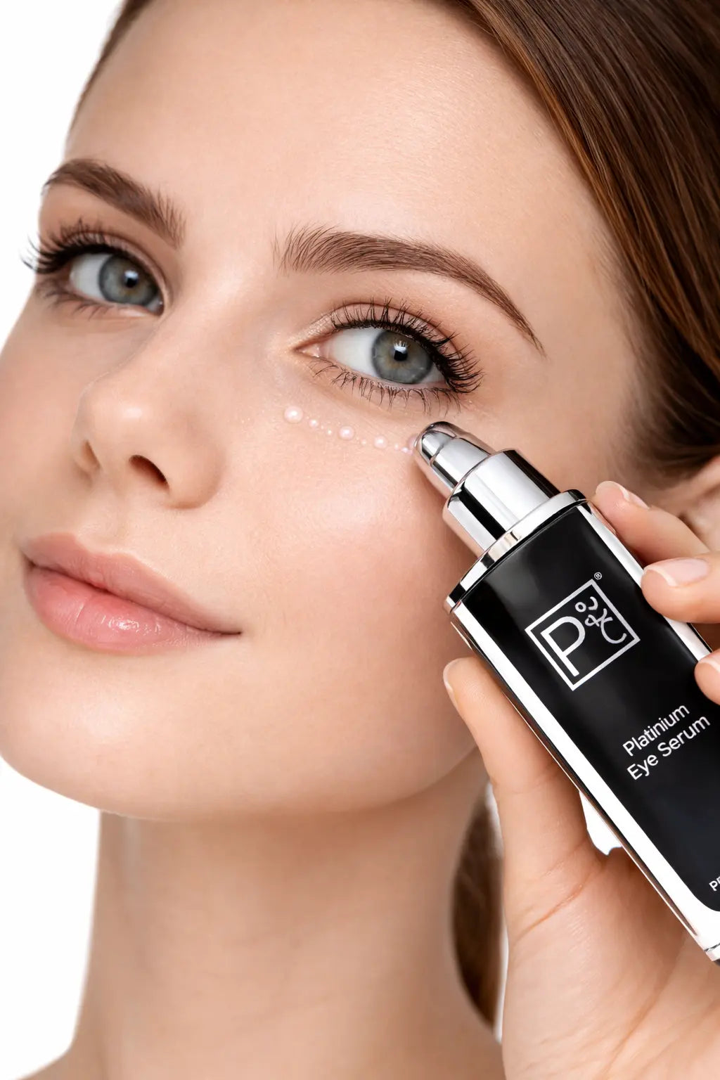 Platinum Eye Serum held near the eye area with silver applicator top