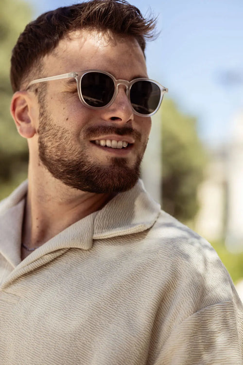 Dark-lens sunglasses on face with light-colored frames