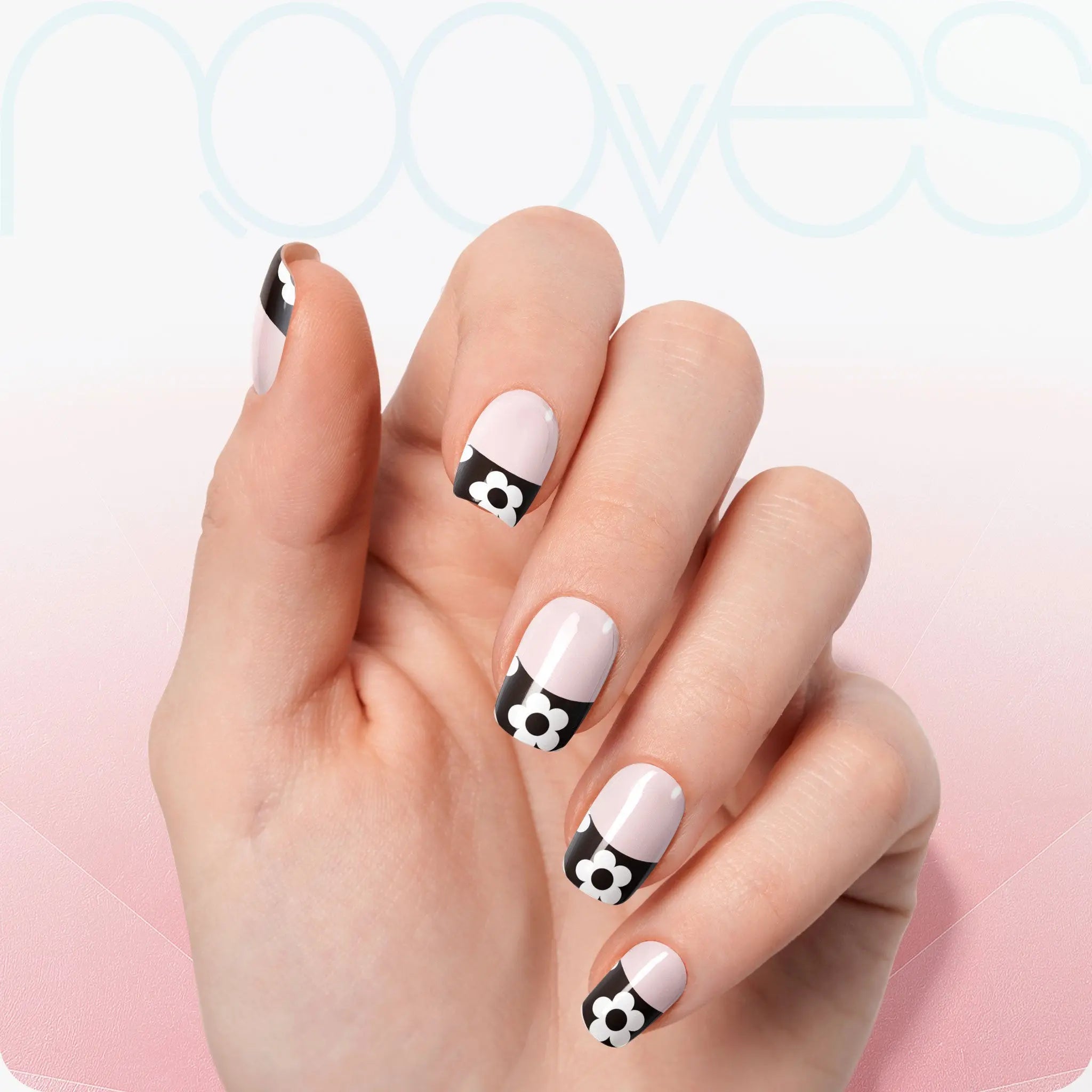 Gel Nail Strips: Handansicht mit hellrosa Nägeln, schwarzen Keilen und weißen Blumen