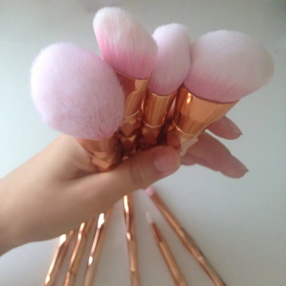 Fan of makeup brushes with rose-gold scales-style handles and pink tapered bristles