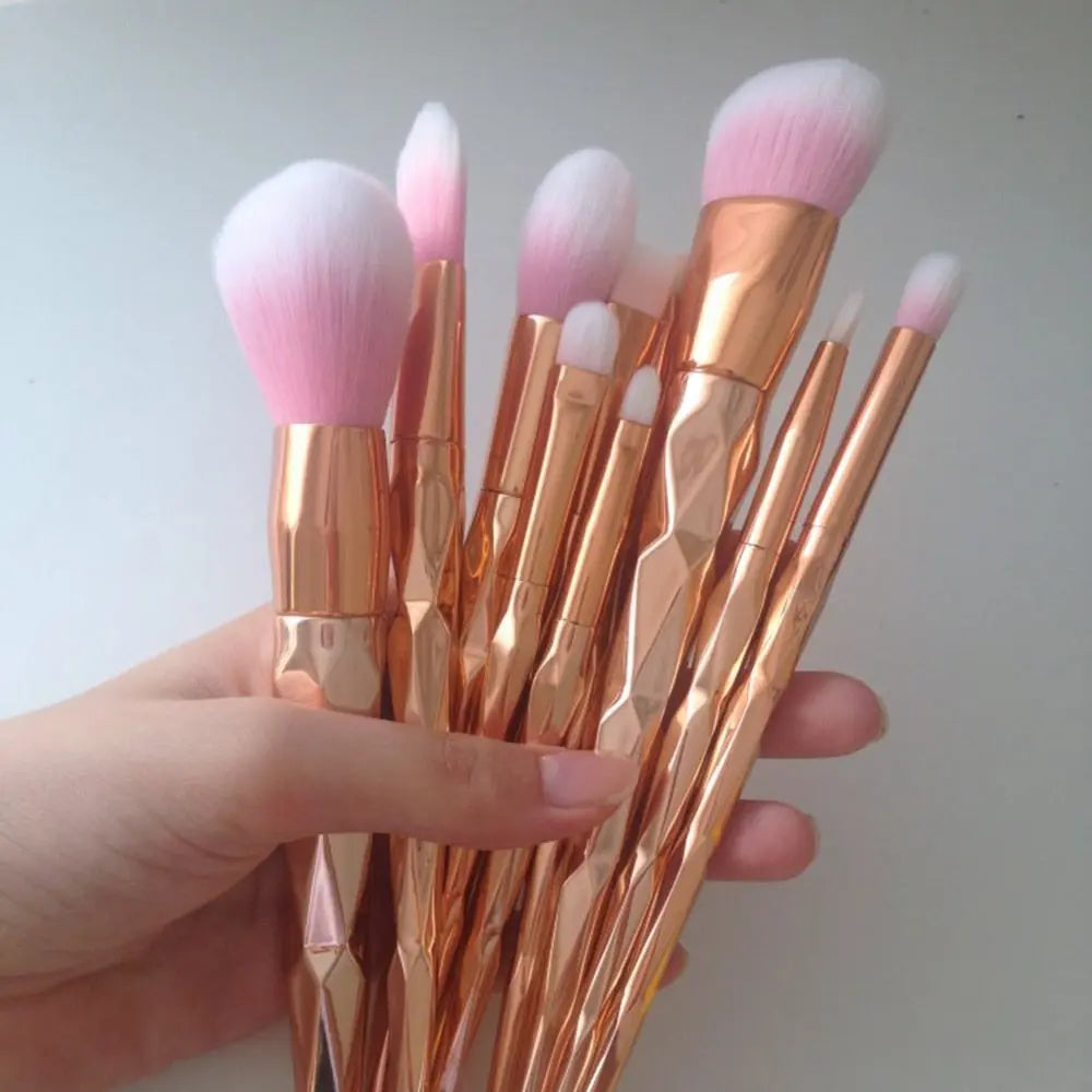 Makeup brushes in hand, rose-gold tubes and fluffy pink bristles, angled close-up