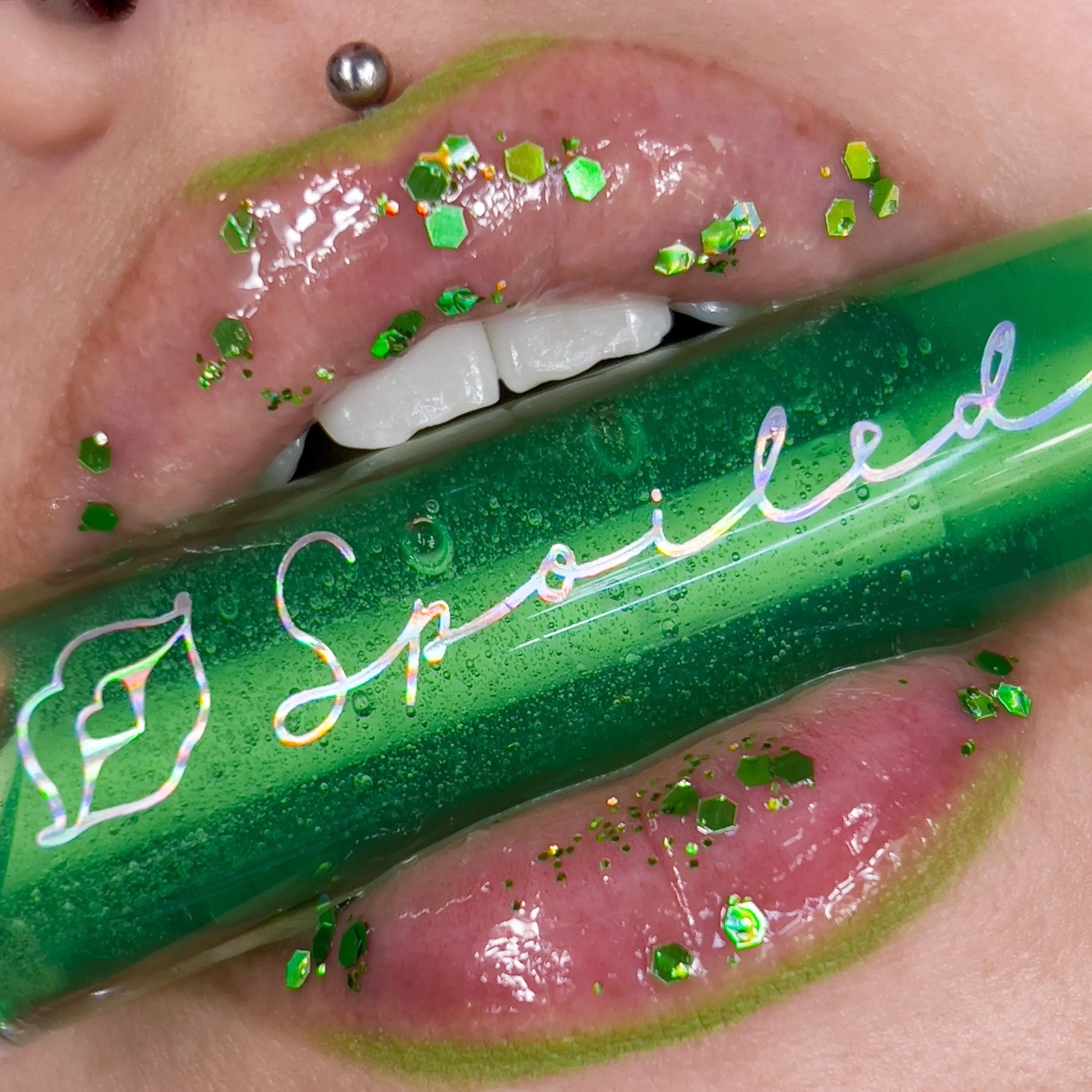 Green lip gloss on lips with glitter sparkle, close-up