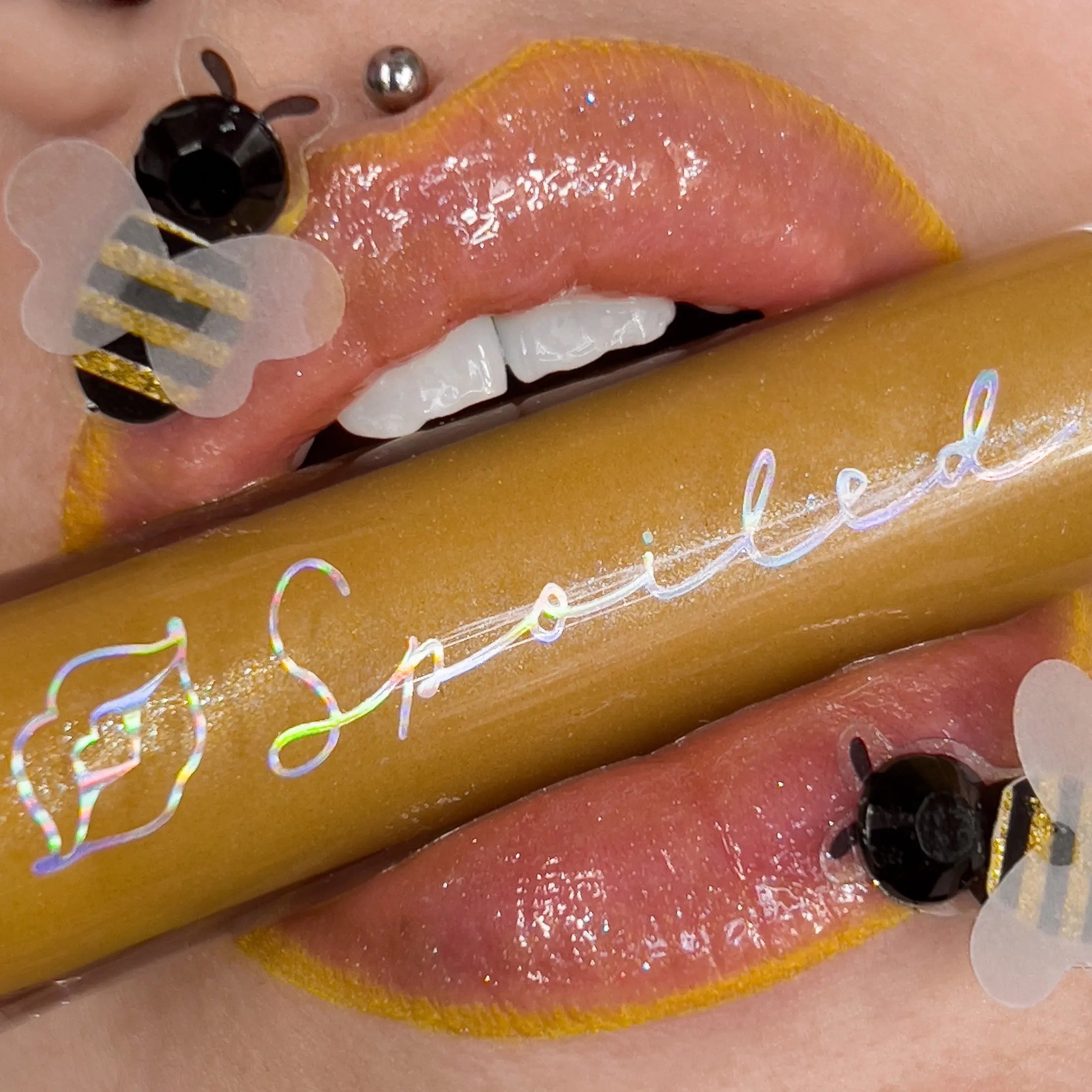 Nectar lip gloss, golden-yellow glossy finish on lips with shiny swatch