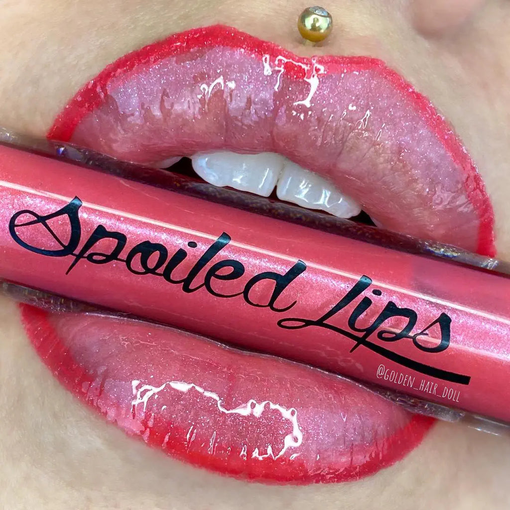 Pink lip gloss tube over glossy lips, with word 'Fool' visible