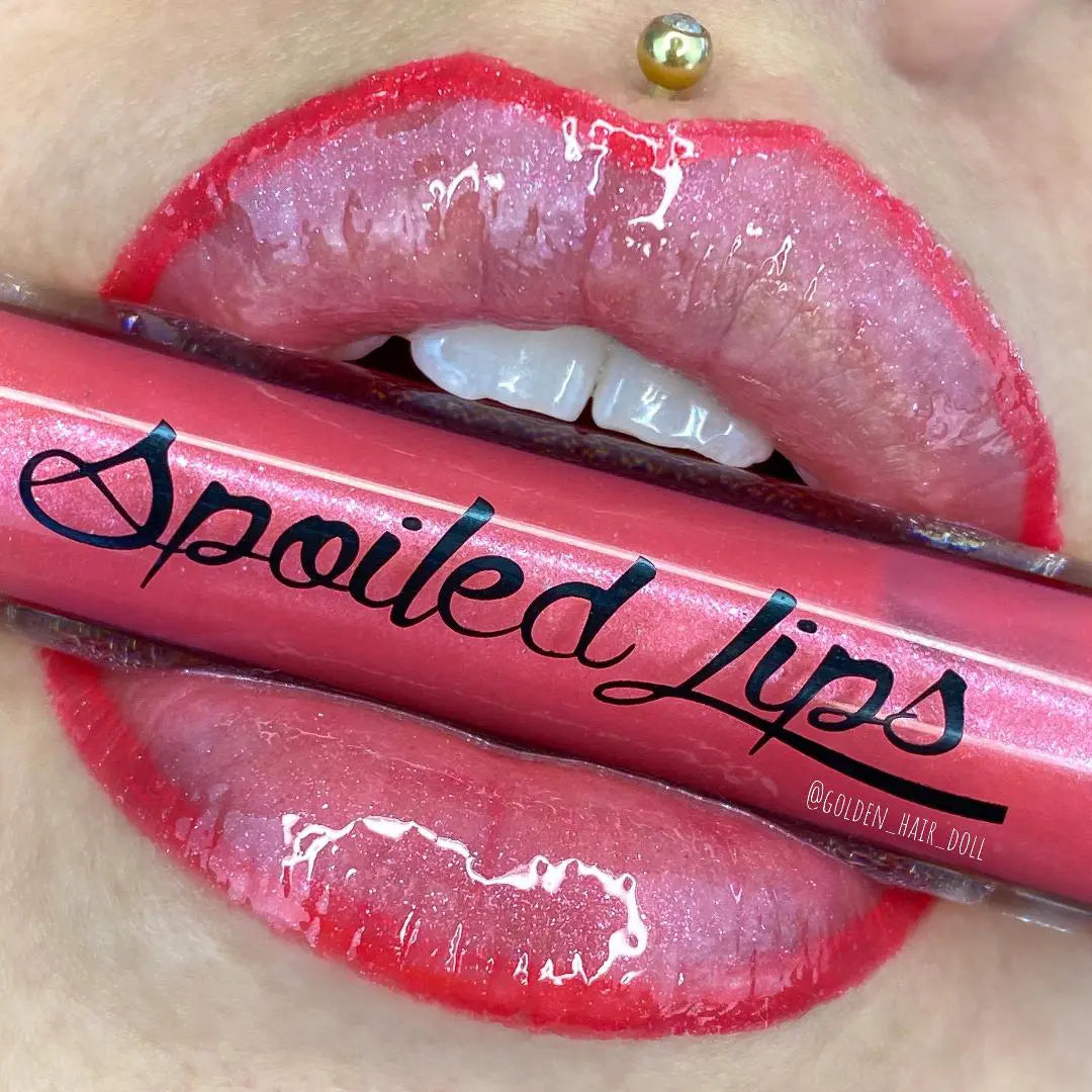 Pink lip gloss tube over glossy lips, with word 'Fool' visible