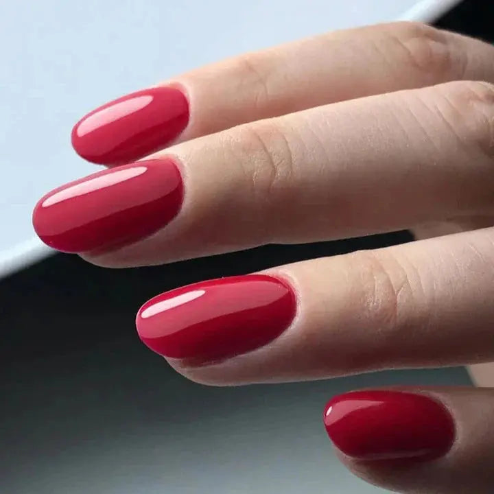 Red gel manicure on hand, glossy rounded nails