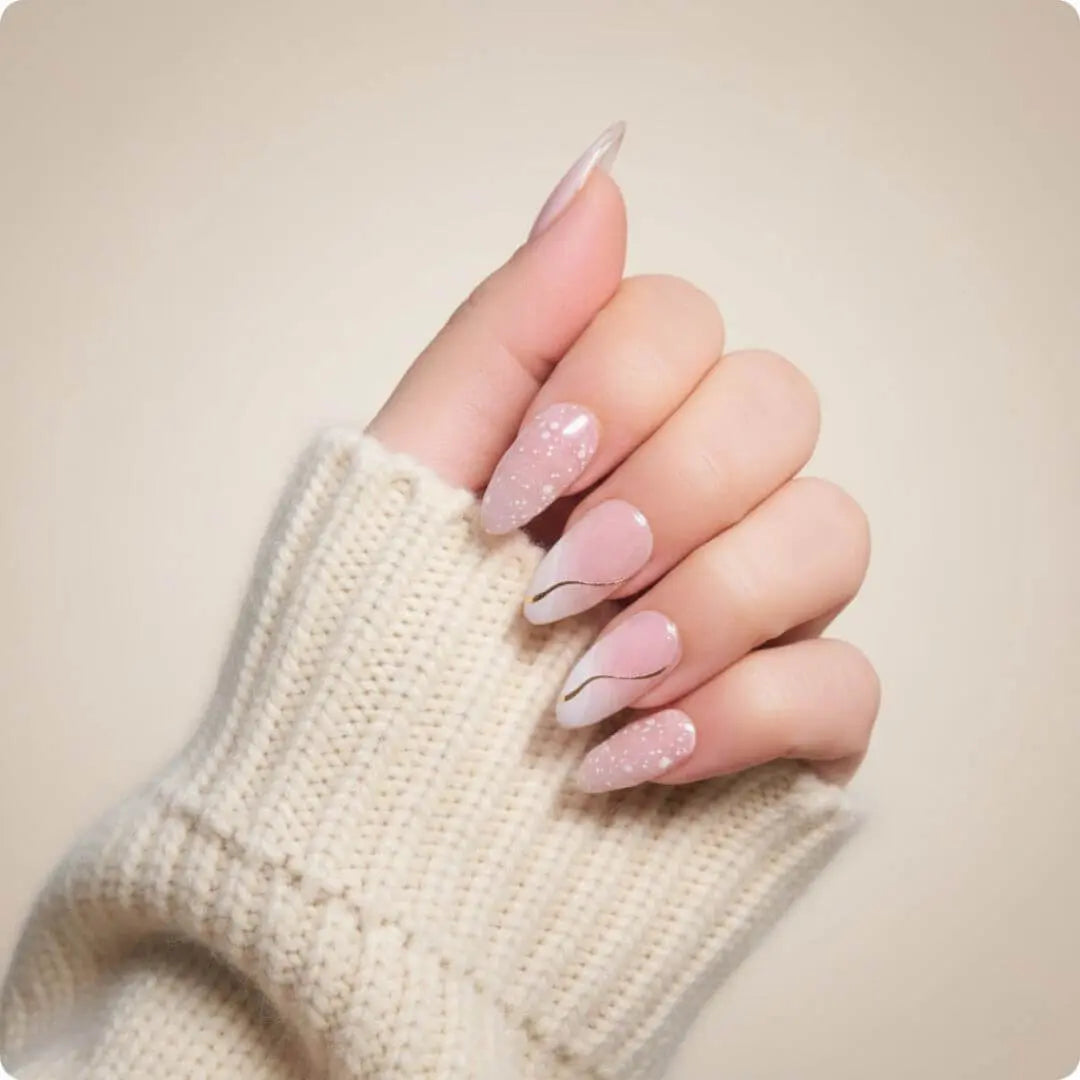 Almond nails with light pink shimmer, nude base, and thin gold half-moon accent
