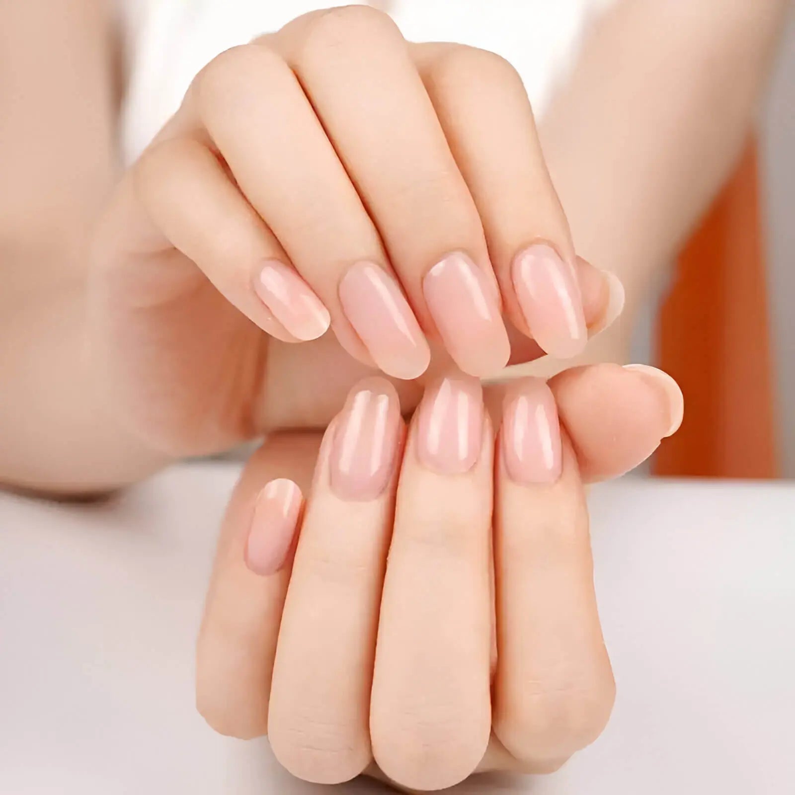 Natural nude gel nail strips, glossy nude nails on crossed hands