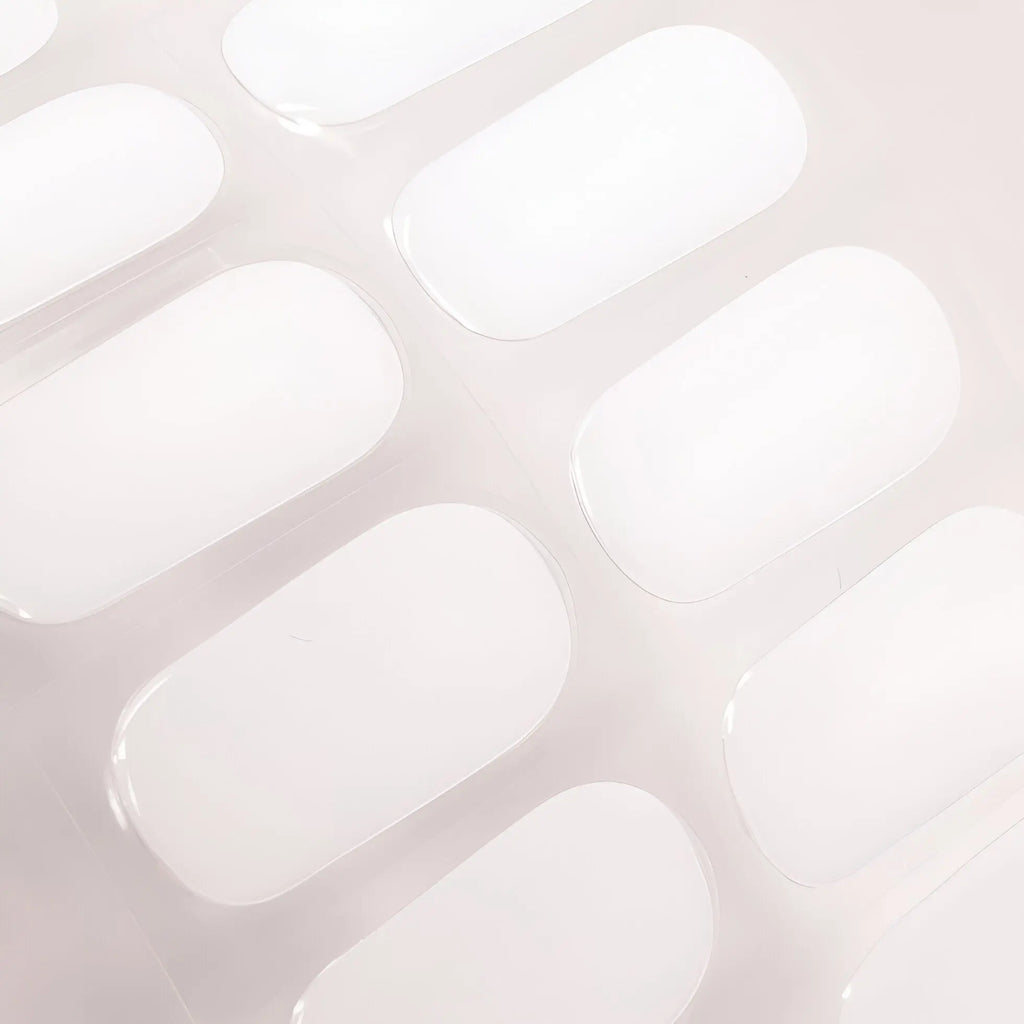 Set of white gel nail strip pieces with glossy oval shapes