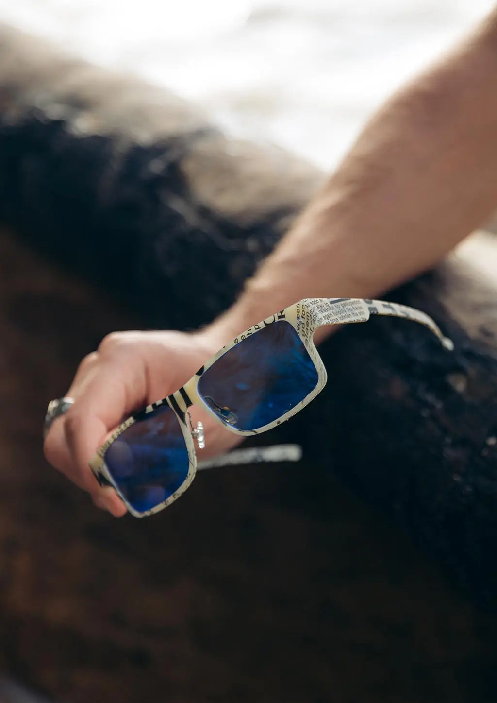 ReVision square paper sunglasses, raw paper frame with blue mirror lenses in hand
