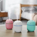 Portable ultrasonic humidifier aroma diffuser with LED, pink, white and teal.
