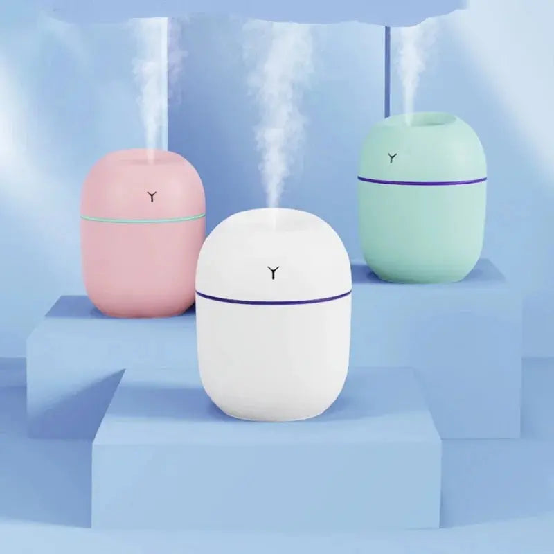 USB aroma diffuser humidifier with LED mist, pink, white and teal.
