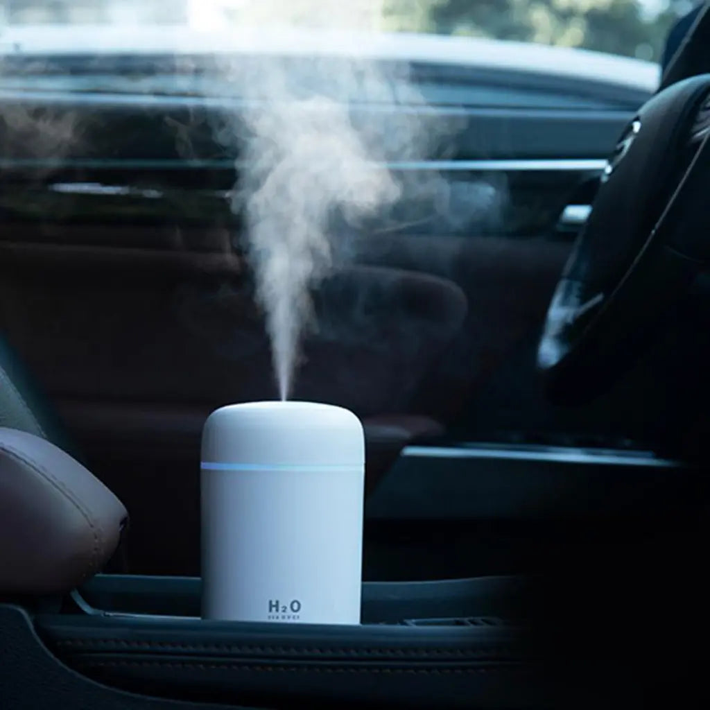 White car humidifier aroma diffuser releasing mist from top