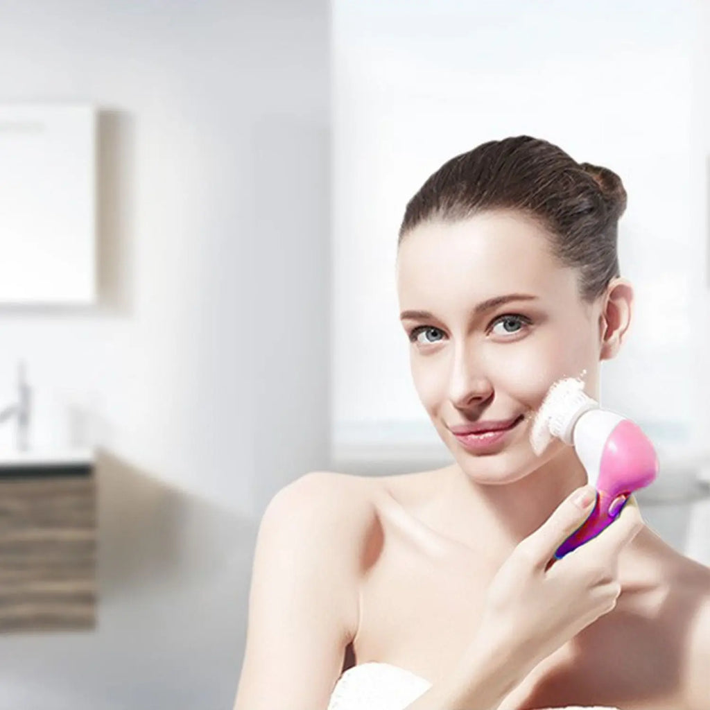 Pink and white facial cleansing brush with foam sponge head held against the cheek