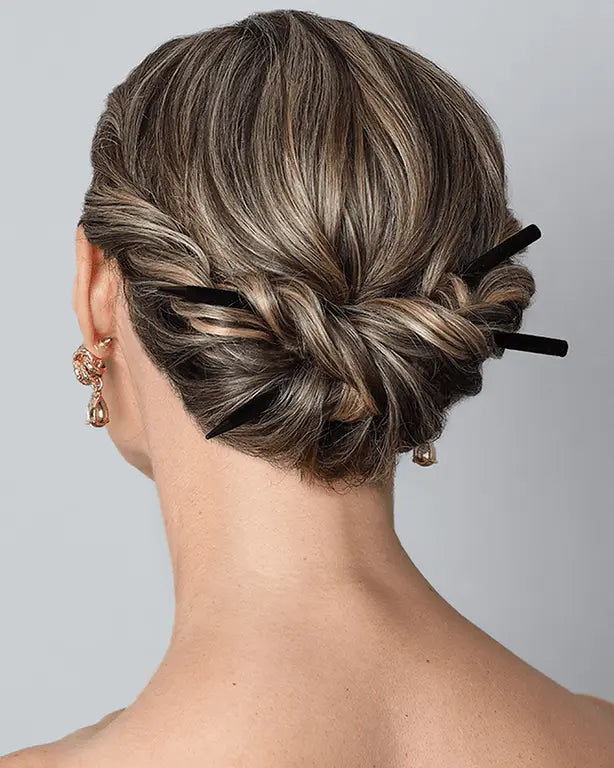 Black velvet-coated hairsticks securing a low bun hairstyle