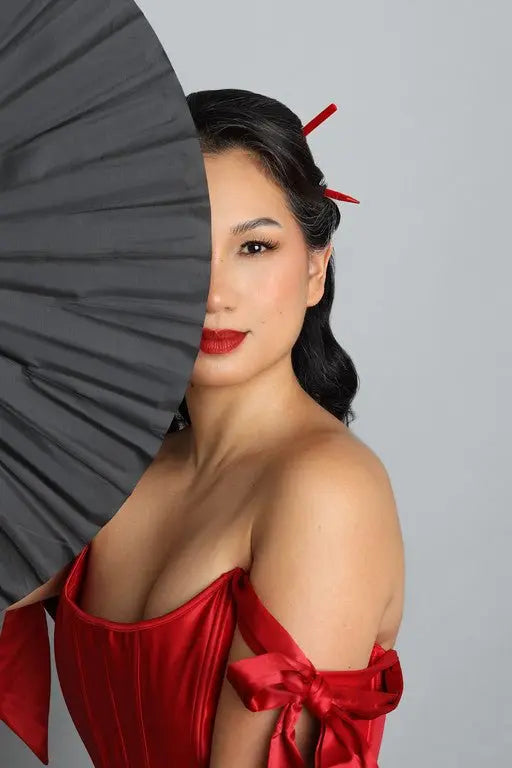Red velvet hairsticks holding a styled updo on dark hair