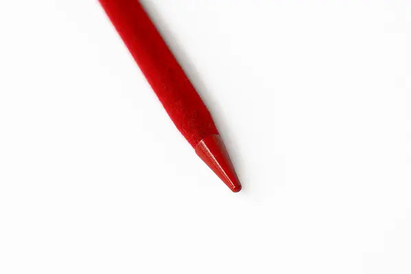 Close-up of red velvet-coated hairstick with pointed tip