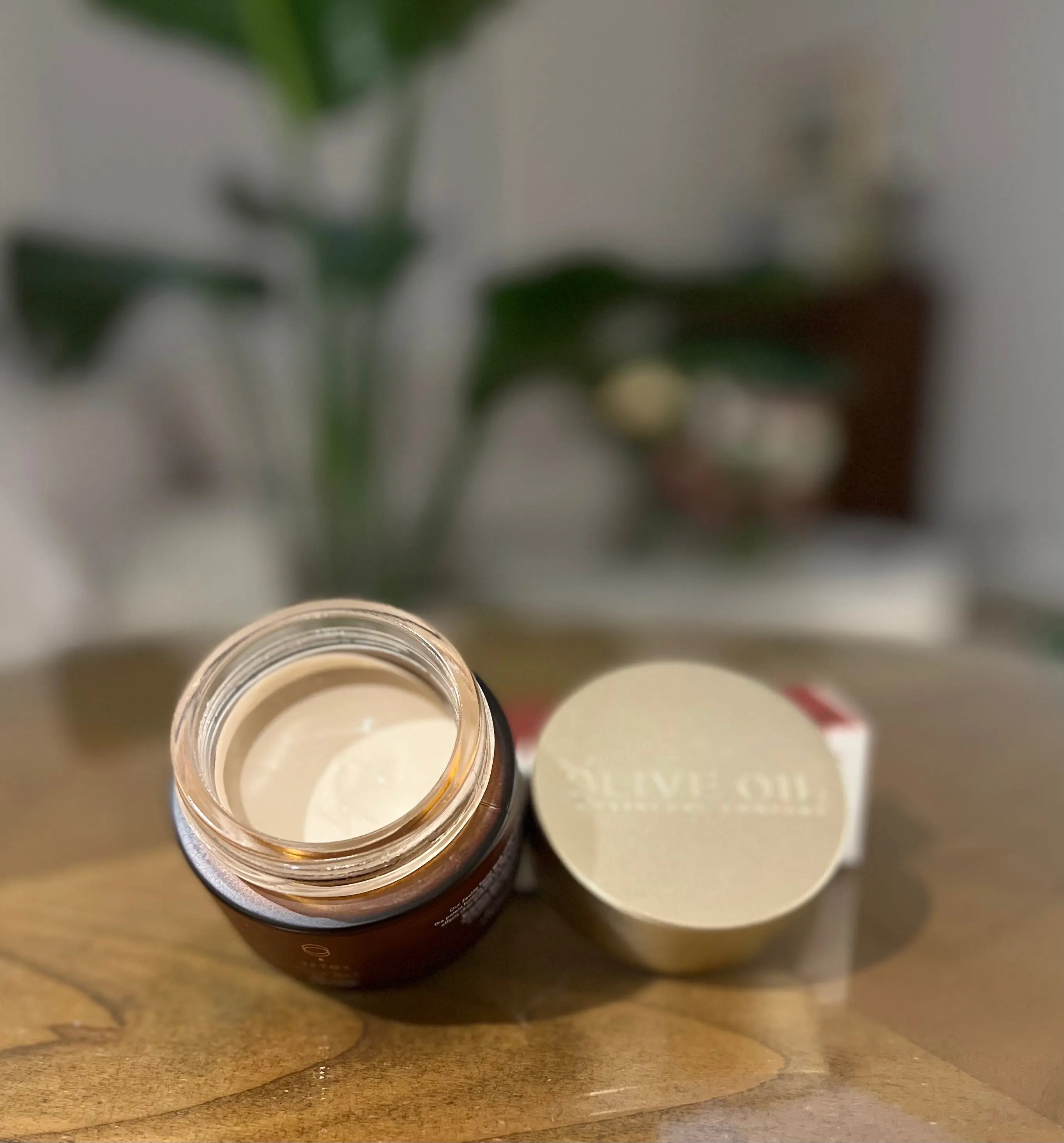Open jar of face clay mask with pale cream paste inside