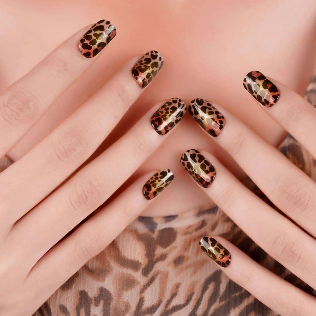 Leopard print nails close-up, almond shape with black-tan spots and orange detailing