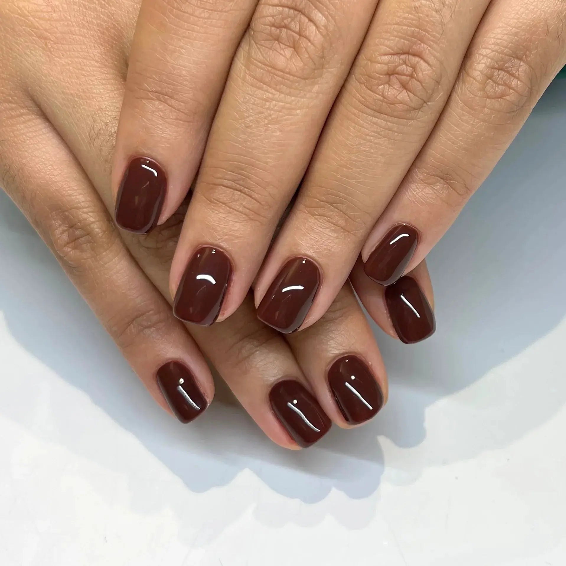 Dark brown nails with white smile highlights and thin line accents