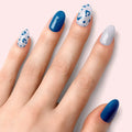 Blue leopard nail set: solid deep-blue nails and white nails with blue spots
