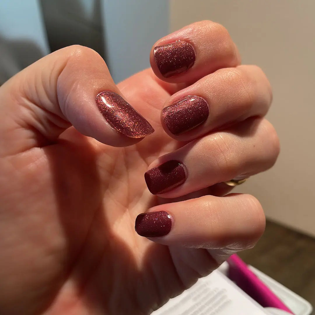 Manicura con tiras de gel Ruby Claret: uñas ovaladas granate, brillo fino